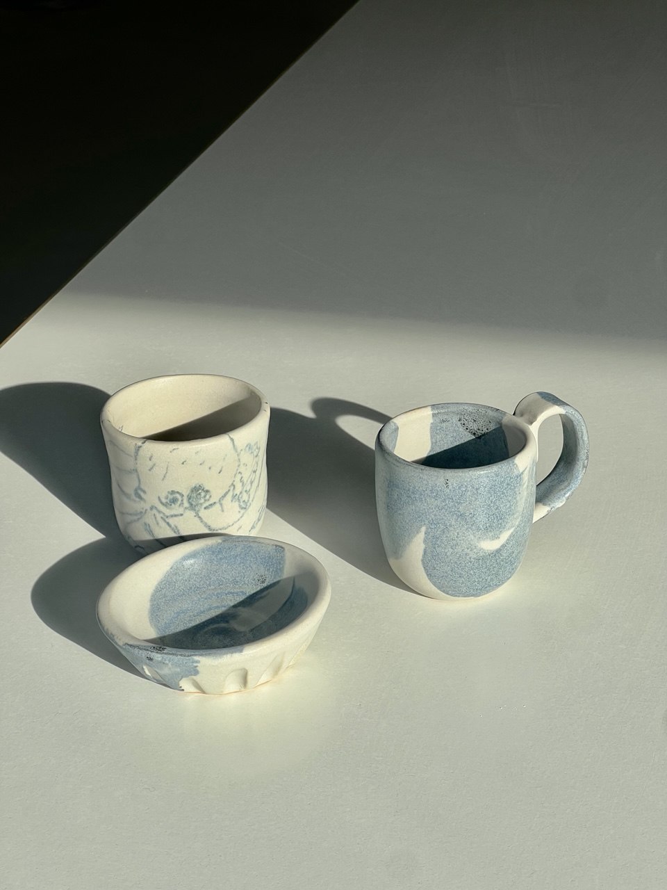 Blue and white cup, mug and dish in sunlight