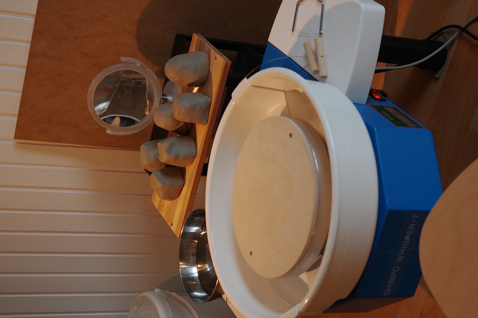 Pottery wheel and wedged clay in the studio